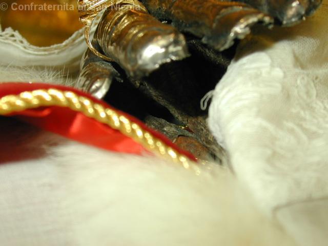 >Dettaglio delle dita che si intravedono sotto la copertura di argento