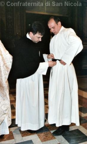 Il priore della Confraternita aiuta a vestire il novizio