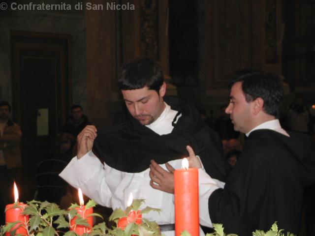 Il priore della Confraternita aiuta al neo confratello ad indossare il rocchetto o scapolare
